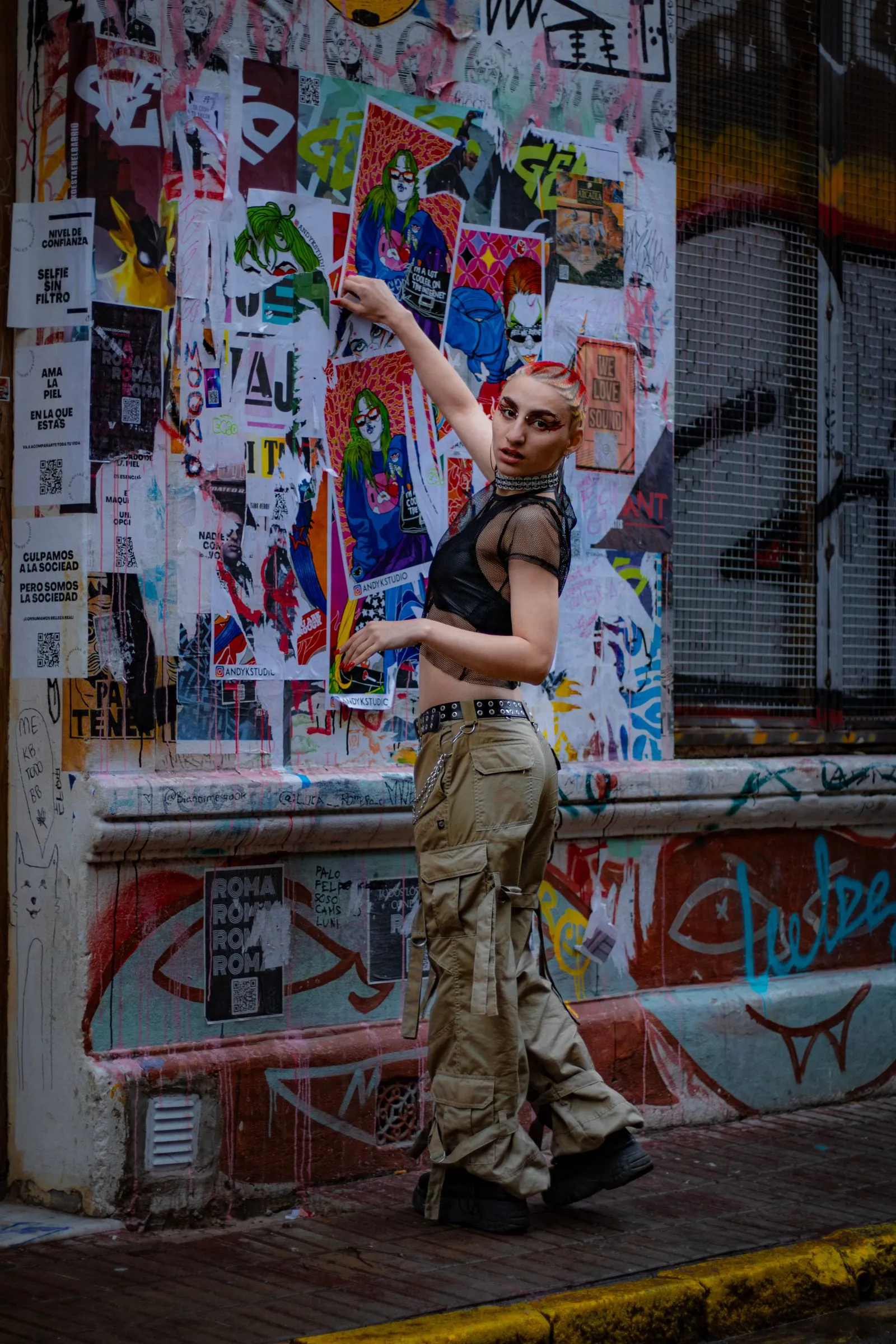 Mujer con pantalón cargo frente a una pared con grafitis