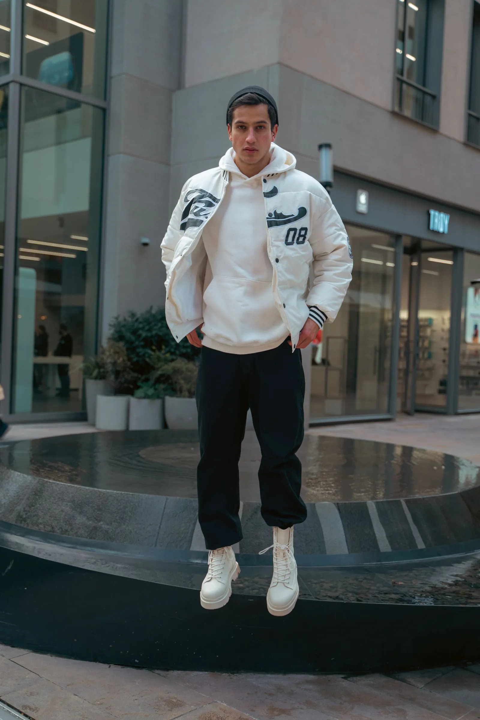 Persona con bomber blanco sobre fondo urbano