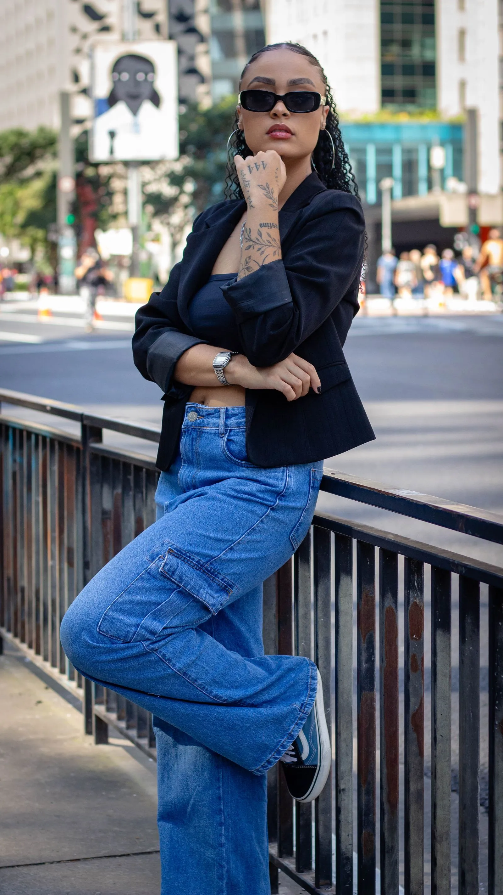Mujer con cargo de denim ancho y gafas de sol en la calle