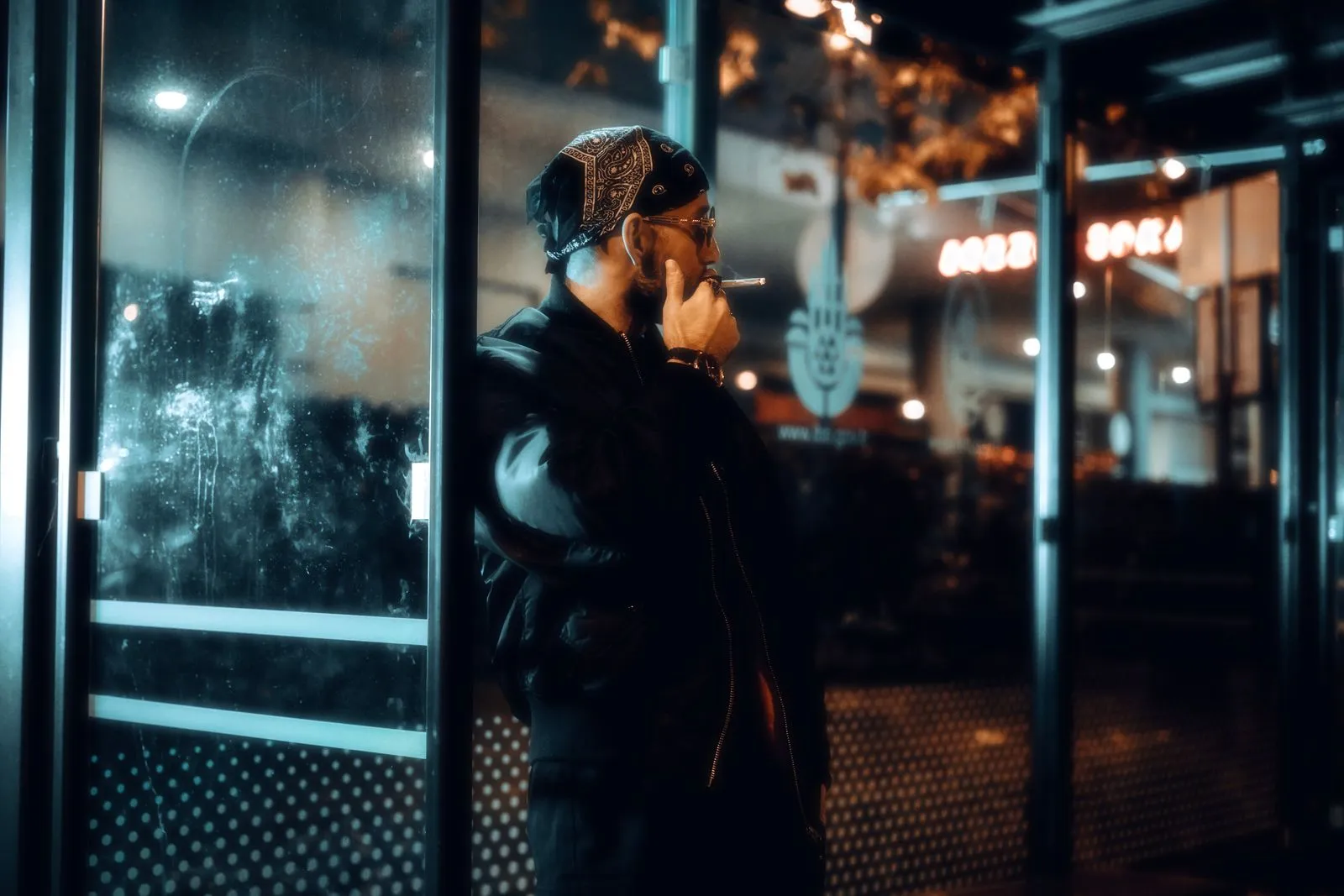 Hombre con bomber negro en la noche urbana